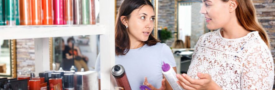 une vendeuse qui conseille un produit de coiffure à une cliente
